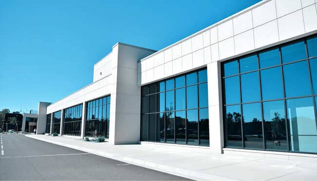 Vorderansicht eines großen weißen Bürogebäudes mit großen Fenstern
